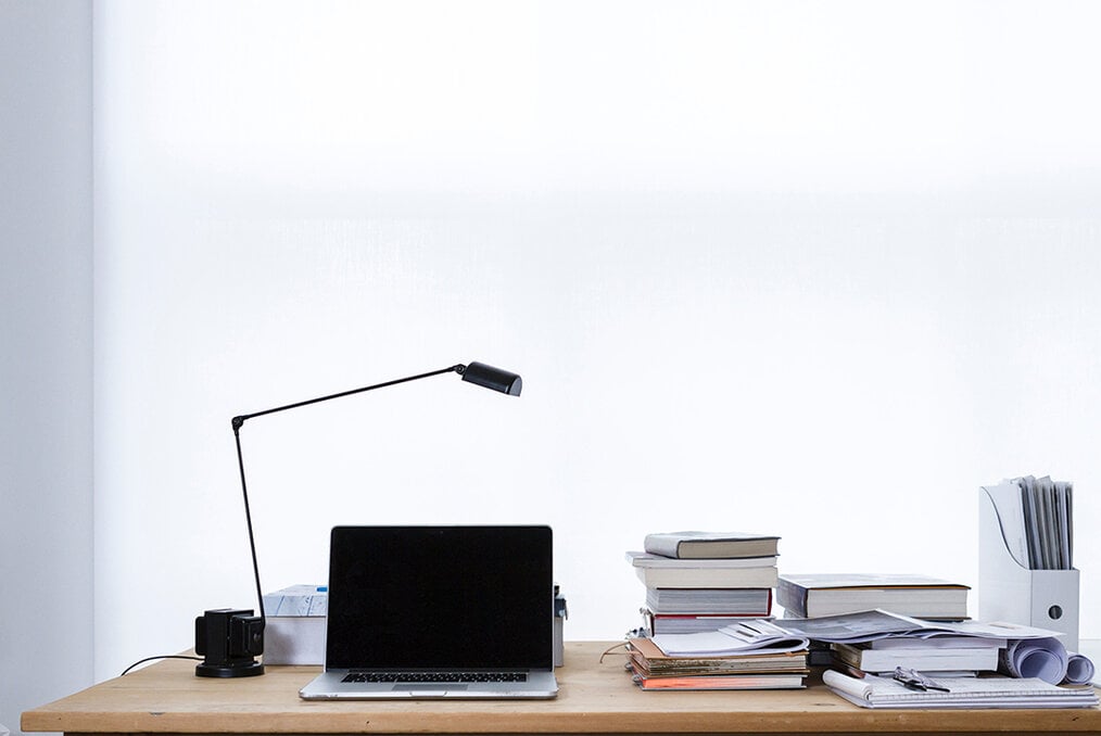 A desk with books on one side and a computer on the other